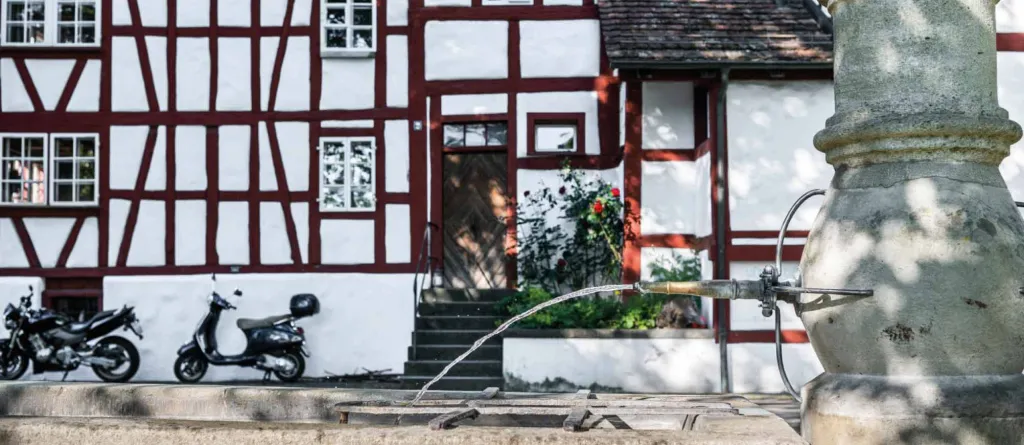 Brunnen und Haus im Riegelbau in Albisrieden